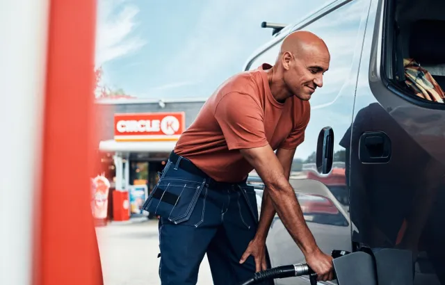 Man happily filling van with fuel at Circle K station